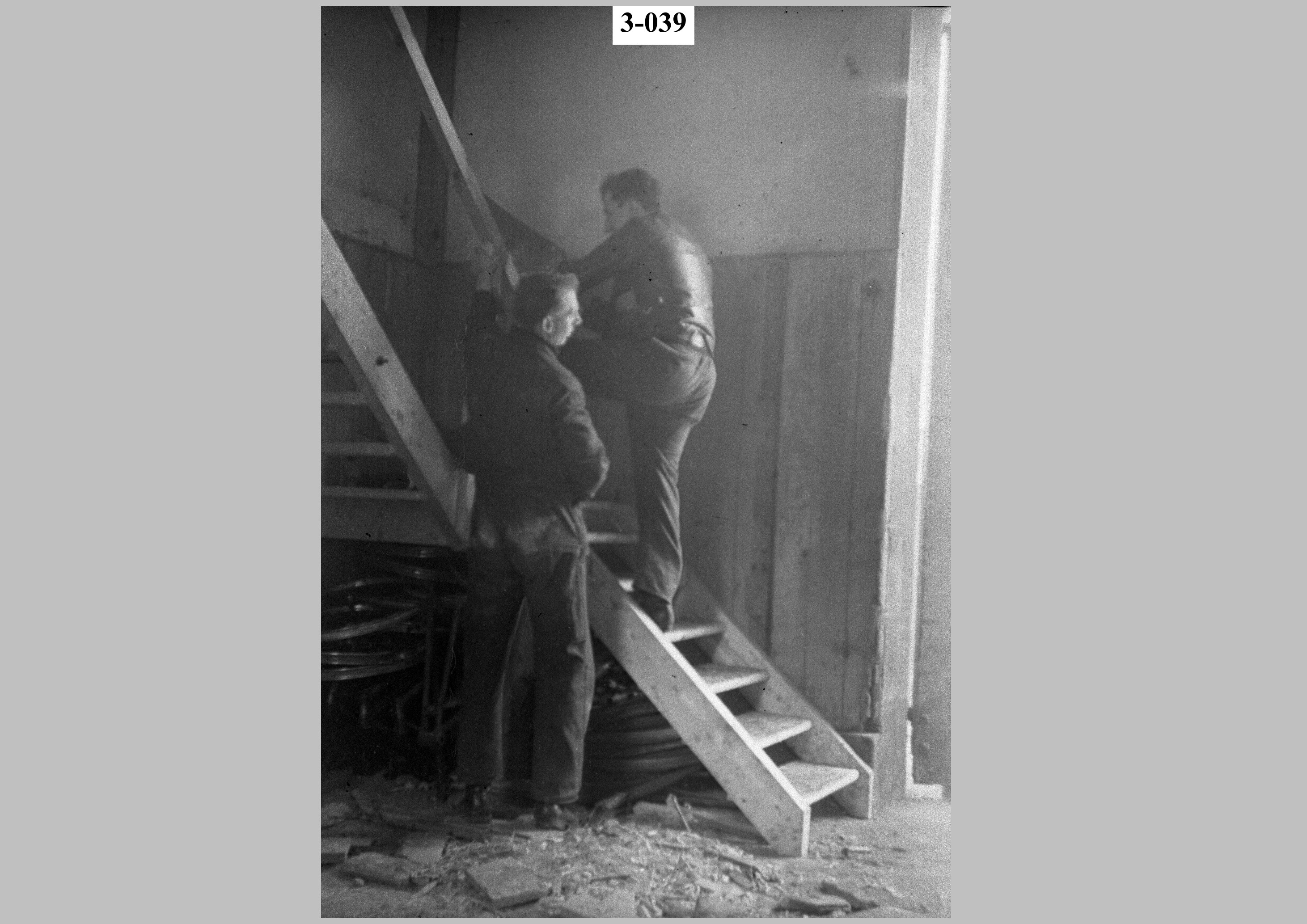 Two men working on a staircase.jpg