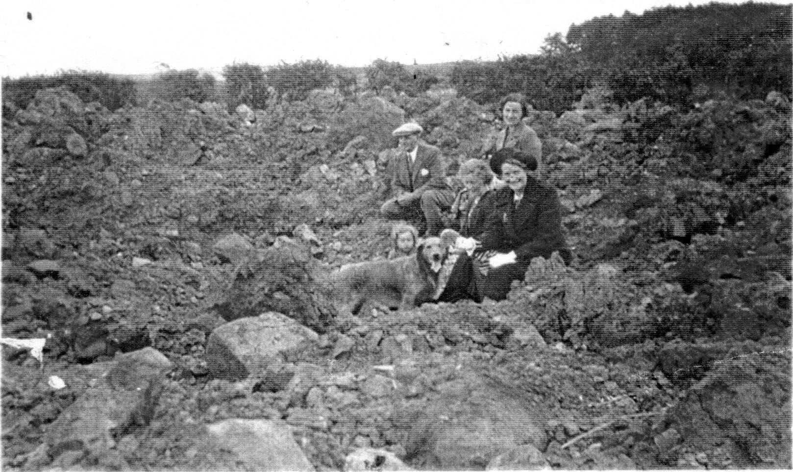 Robin Ross, Mrs McLean, Mrs McDonald and Jean McLean sitting in a mine crater east of Traprain.jpg